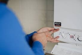 Engineer servicing a boiler control panel